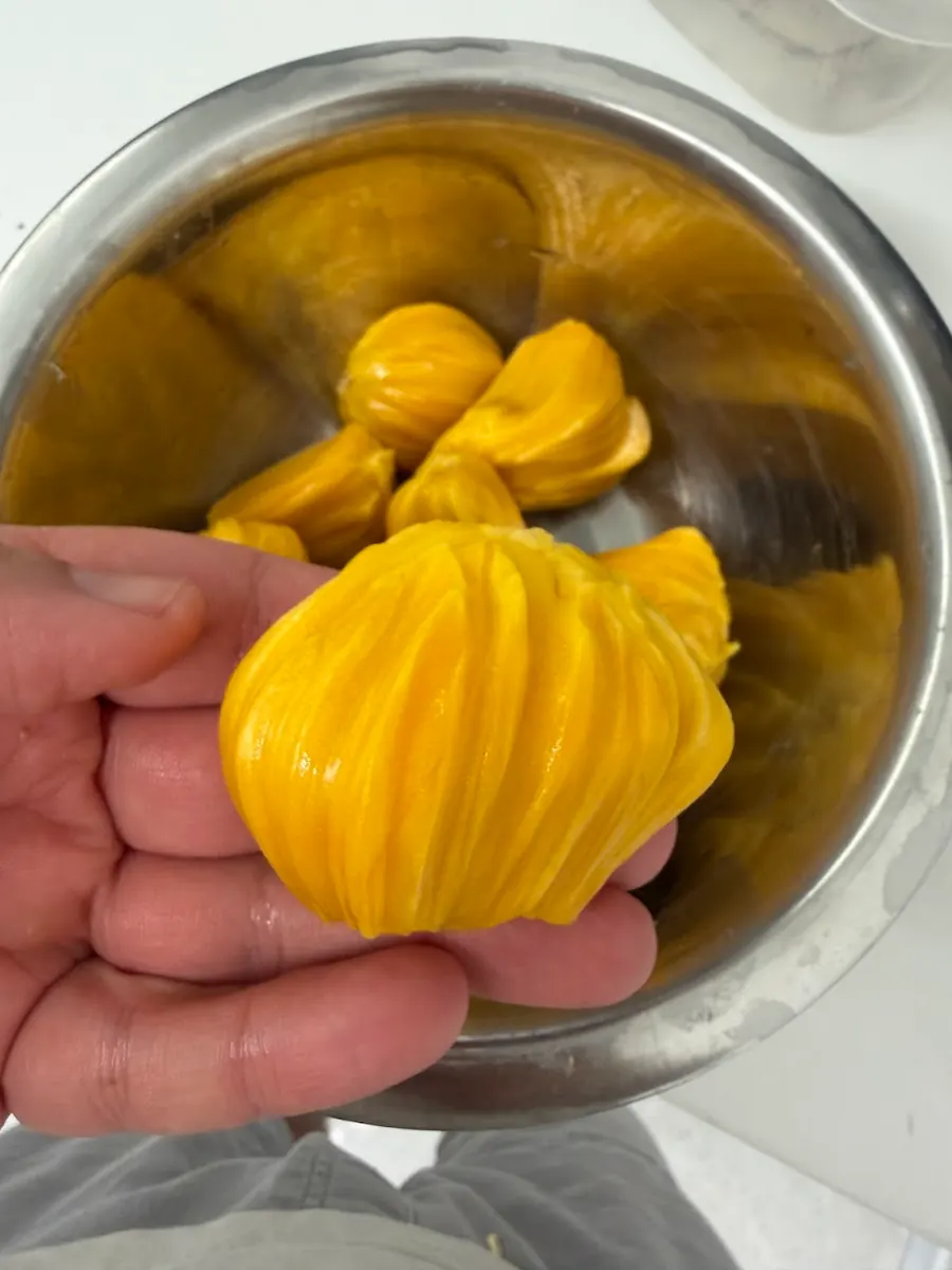 פלח ג'קפרוט מוחזק ביד מעל קערת נירוסטה